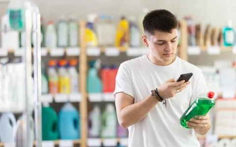 Young man scanning qr code for dishwashing Foto stock