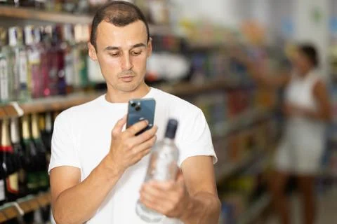 Young man scanning qr code for vodka Stock Photos