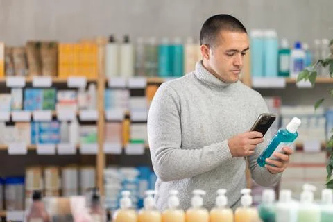 Young man scanning qr code of mouthwash Stock Photos