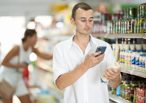 Young man scanning qr code for mayonnaise Stock-Fotos