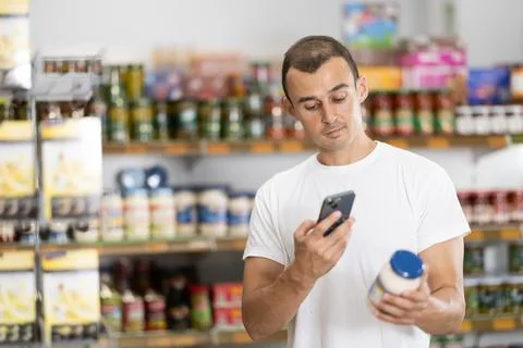 Young man scanning qr code for mayonnaise Stock-Fotos