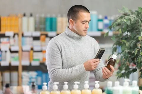 Young man scanning qr code of syrup Stock Photos