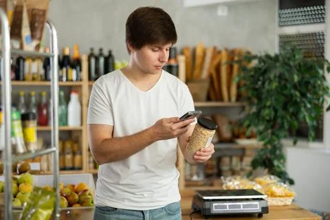 Young man scanning qr code of beans Stock-Fotos