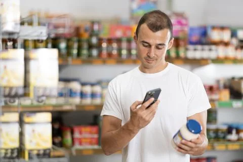 Young man scanning qr code for mayonnaise Fotos Stock