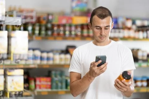 Young man scanning qr code of sauce Stock-Fotos