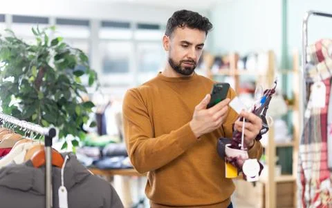 Young man scans qr code of womens lingerie in store Stock-Fotos