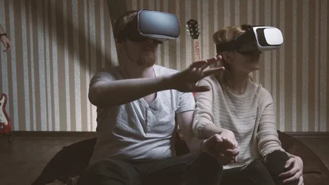 Young man scared of his friends that play via virtual reality glasses Stock Footage 74367474