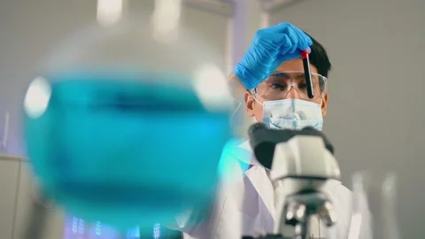 Young man scientist looking Vacutainer tubes inspection and shake biochemical 動画素材 131874015