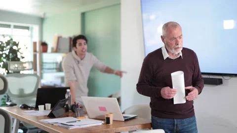 Young man scolding elderly man holding farewell letter in office Stock Footage 341532073