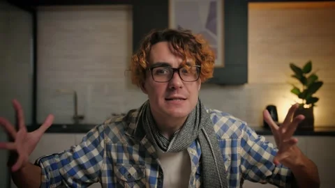 Young man screams into the camera in home interior.Close-up Angry Guy with Stock Footage 221619664