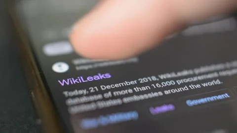 Young man scroll wikileak website on iphone. wikileak by Assange Stock Footage 265470343