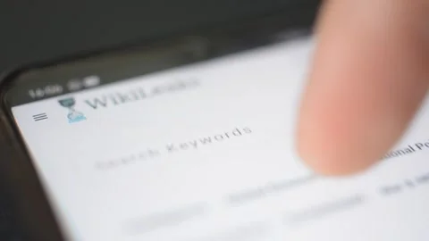 Young man scroll wikileak website on iphone. wikileak by Assange Stock Footage 265470357