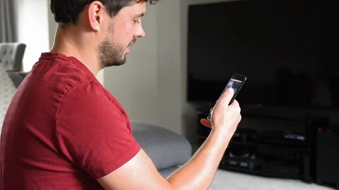 Young man scrolling through social media, consuming Stock Footage 92282746