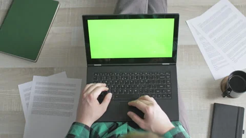 Young man scrolling through websites on his laptop with green screen Stock Footage 142763960