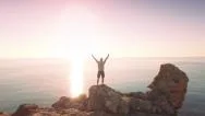 Young Man On Sea Vacation Standing On Edge Of Ocean Cliffs Enjoying Sunrise Stock Footage