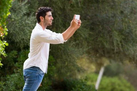 Young man searching internet coverage outdoor Stock Photos