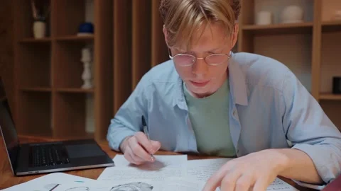 Young man searching through the dictionary book and writing in his notes Stock Footage 164374193