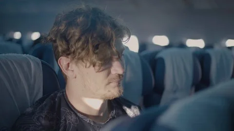 Young man seat in an airplane using the touch screen Stock Footage 94473166