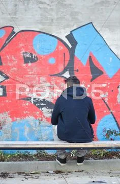 Young man seen from the back looking at a graffiti Stock Photos