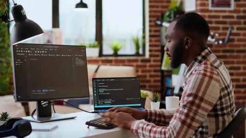 Young man seen programming software code on his laptop in a sleek home office Stock Footage 319713145