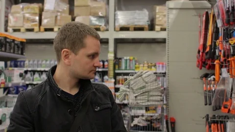 Young man selecting tools in the shop Stock Footage 75523021