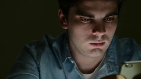 Young Man Sending Text Message On Mobile Phone Late At Night Stock Footage 75783278