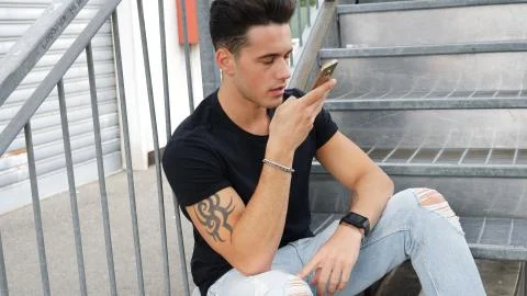 Young man sending voice message with cell phone Stock Photos