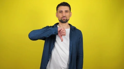 A young man is seriously looks at the camera and shows dislike with hand Stock Footage 119860335