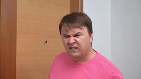 Young man seriously puts finger to lips forcing to shut up Video stock 265044863