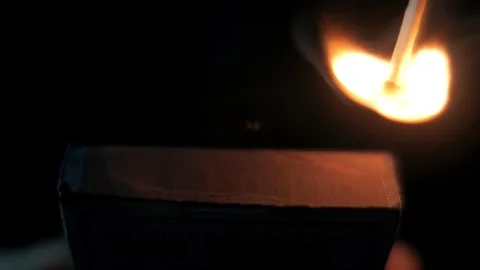 Young man sets fire to a match in the dark. Slow motion shot Stock Footage 102654146