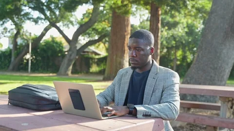 A Young Man Sets Up his Laptop Outdoors, Embracing His Outdoor Workspace.  Stock Footage 308482906