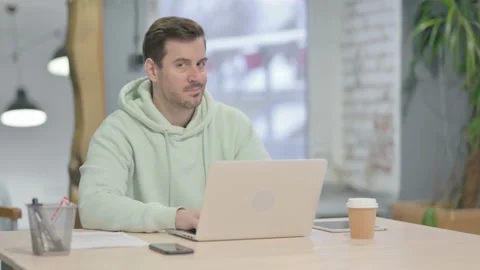 Young Man Shaking Head in Rejection while Working on Laptop Vidéo 230508886