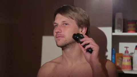 Young man shaving in front of the mirror. Stock-Footage 76116572
