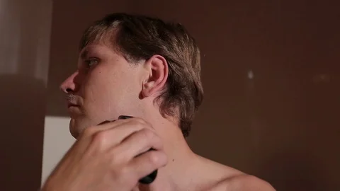 Young man shaving in front of the mirror. Stock Footage 76117048