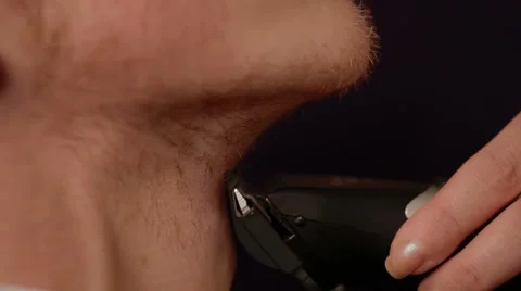Young man shaving his beard off with an electric shaver Stock Footage 52470593