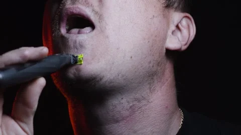 Young man shaving his face with a trimmer for shaving Video stock 308537882