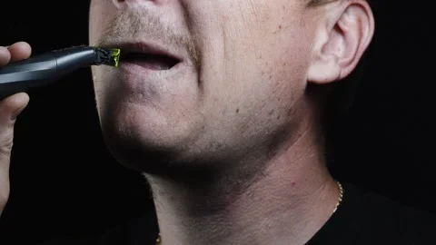 Young man shaving his face with a trimmer for shaving Video stock 308537889