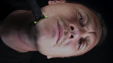 Young man shaving his face with a trimmer Stock-Footage 308538121