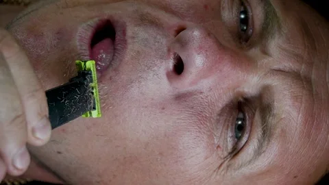 Young man shaving his face with a trimmer Stock-Footage 308538136