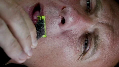 Young man shaving his face with a trimmer Stock Footage 308538142