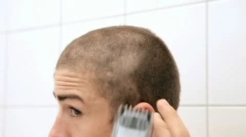 Young man shaving his head with a clipper for a buzzed haircut Stock Footage 22249941