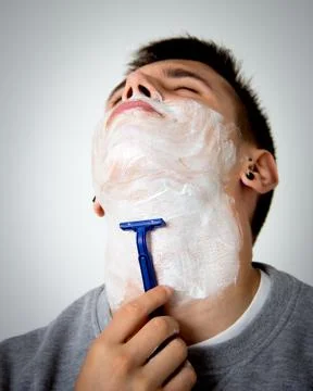Young man shaving Stock Photos