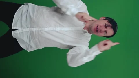 Young man in shirt dancing, having fun on a green background. Video stock 148447414