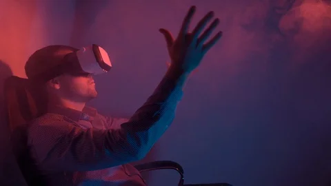 Young man in shirt using VR headset interacts with virtual reality Stock Footage 101848217