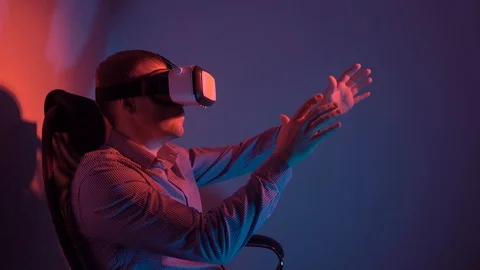 Young man in shirt using VR headset interacts with virtual reality Stock Footage 101848325