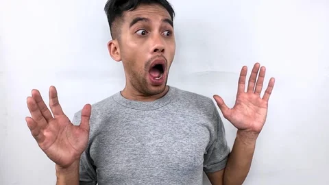 Young Man with Shocked Expression and Raised Hands on White Background. Stock Footage 315229917