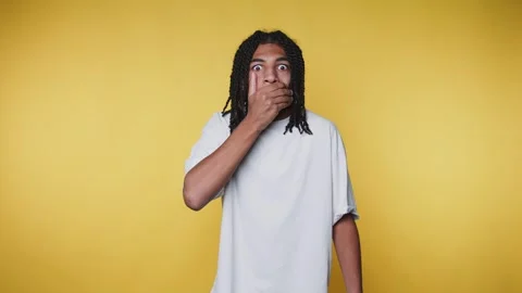 Young man with a shocked expression, covering his mouth in surprise likely .. Stock Footage 313280286