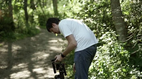 Young man shooting video with electornic steadicam Stock Footage