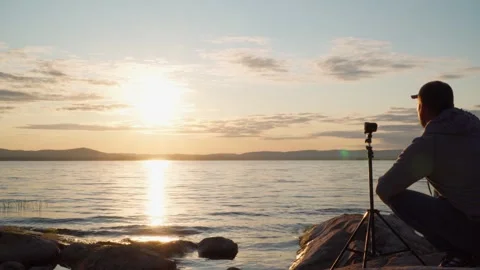 A young man shoots clouds in slow motion with an action camera. Stock Footage 243700248