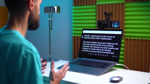 A young man shoots a video on a camera while reading text from a teleprompter on Stock Footage 259308021
